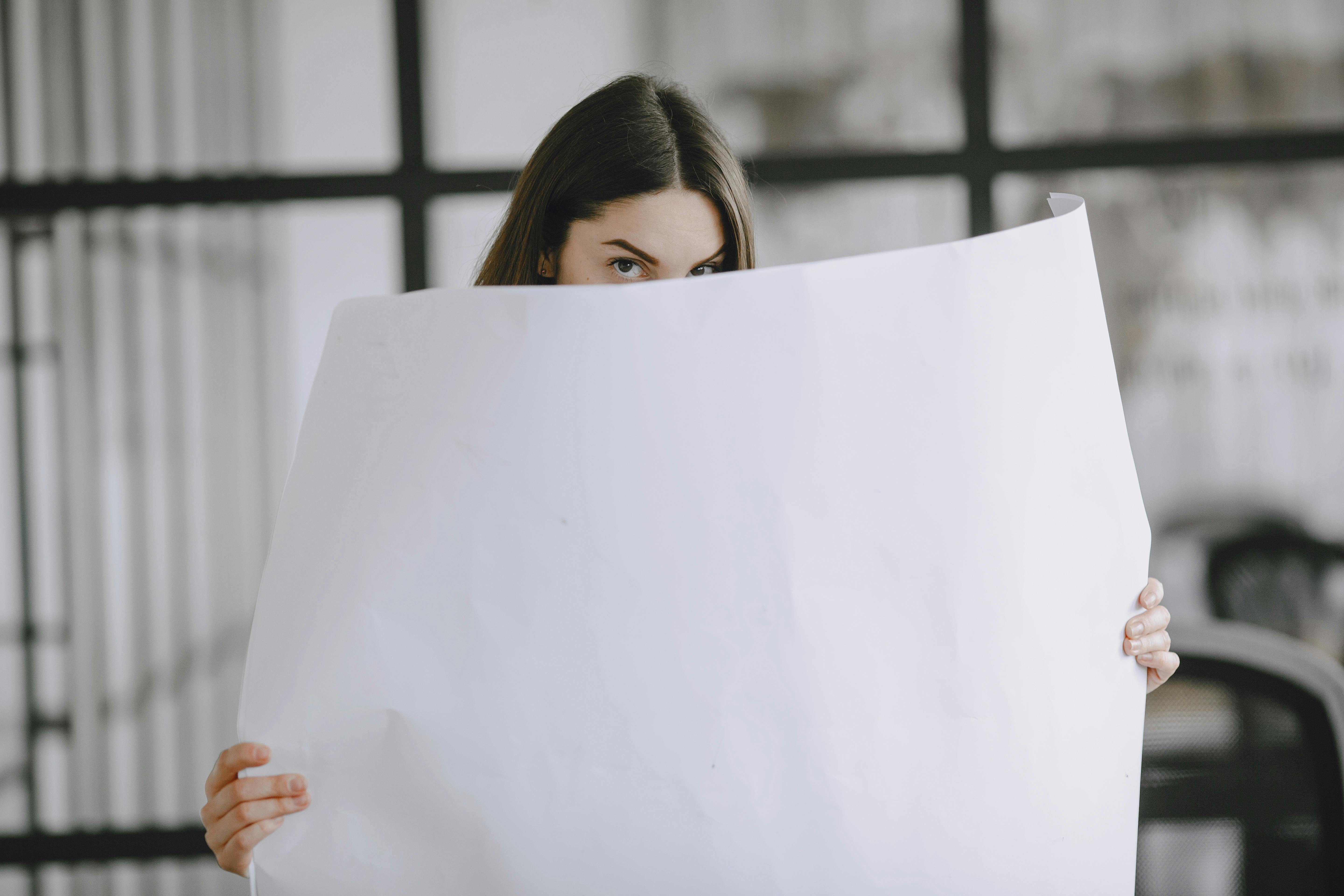 A woman with a big sheet of white paper